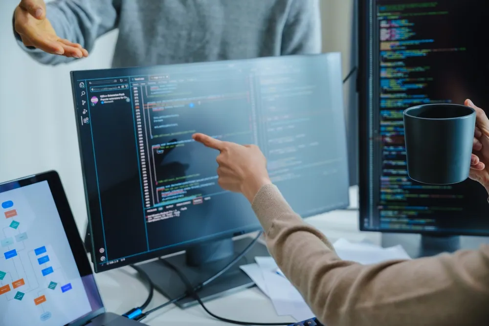 Zespół developerów omawia projekt WWW w biurze — planowanie zakresu i etapów realizacji.