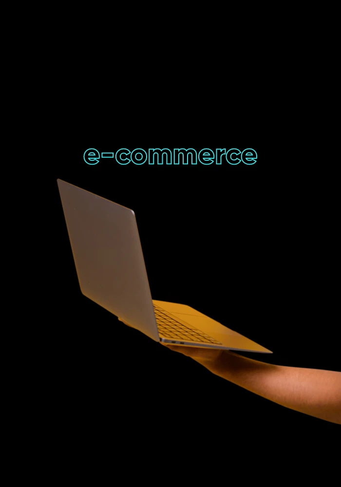 Dłoń trzymająca laptopa pod napisem e-commerce